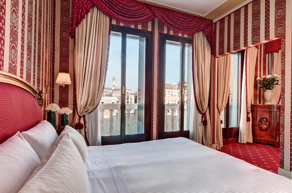 a bedroom with a large bed with a window at Sina Palazzo Sant'Angelo in Venice