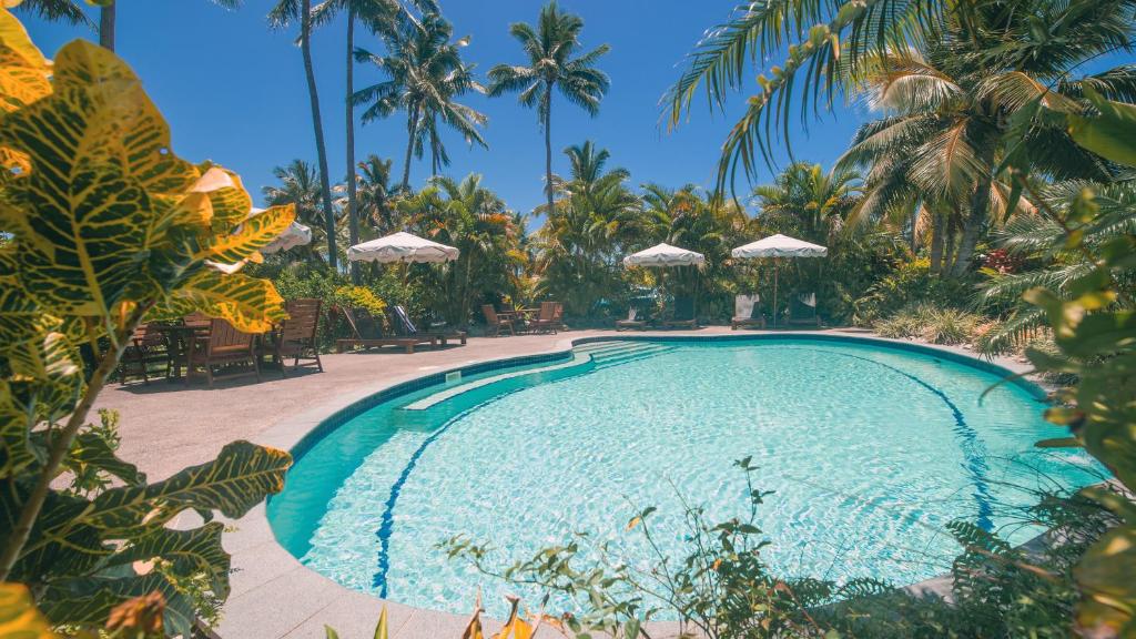 a swimming pool in a resort with palm trees at Arcadia Retreat Rarotonga in Rarotonga