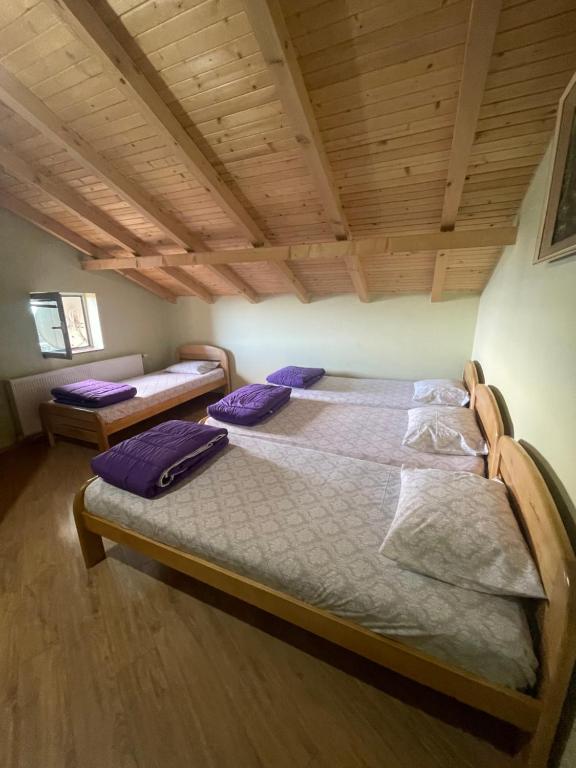 two beds in a room with wooden ceilings at Villa 80 Kodra e Diellit in Tetovo
