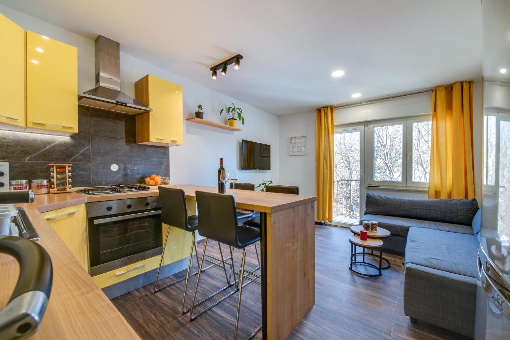 a kitchen and living room with yellow cabinets at Apartment Niksa in Pula