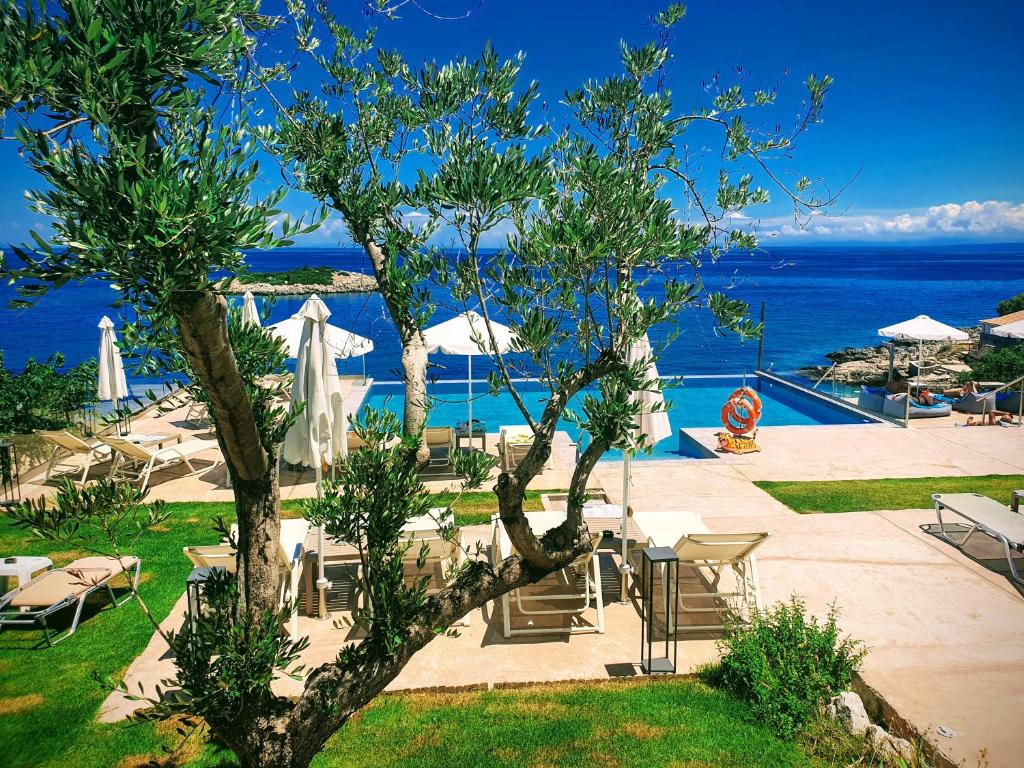 een resort met een boom en stoelen en de oceaan bij Il sogno di Zante in Skinária
