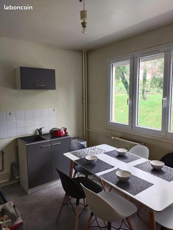 une cuisine avec une table, des chaises, une table et une fenêtre dans l'établissement Appartement à 15mn du centre ville de Rouen, à Canteleu