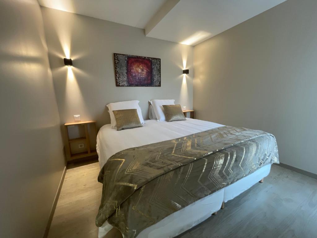 a bedroom with a large bed with two pillows at La Maison de Jade in La Roche-de-Glun