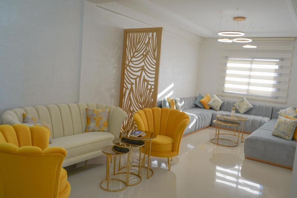 ein Wohnzimmer mit gelben Stühlen und einem Sofa in der Unterkunft Most Beautiful Apartment in Safi in Safi