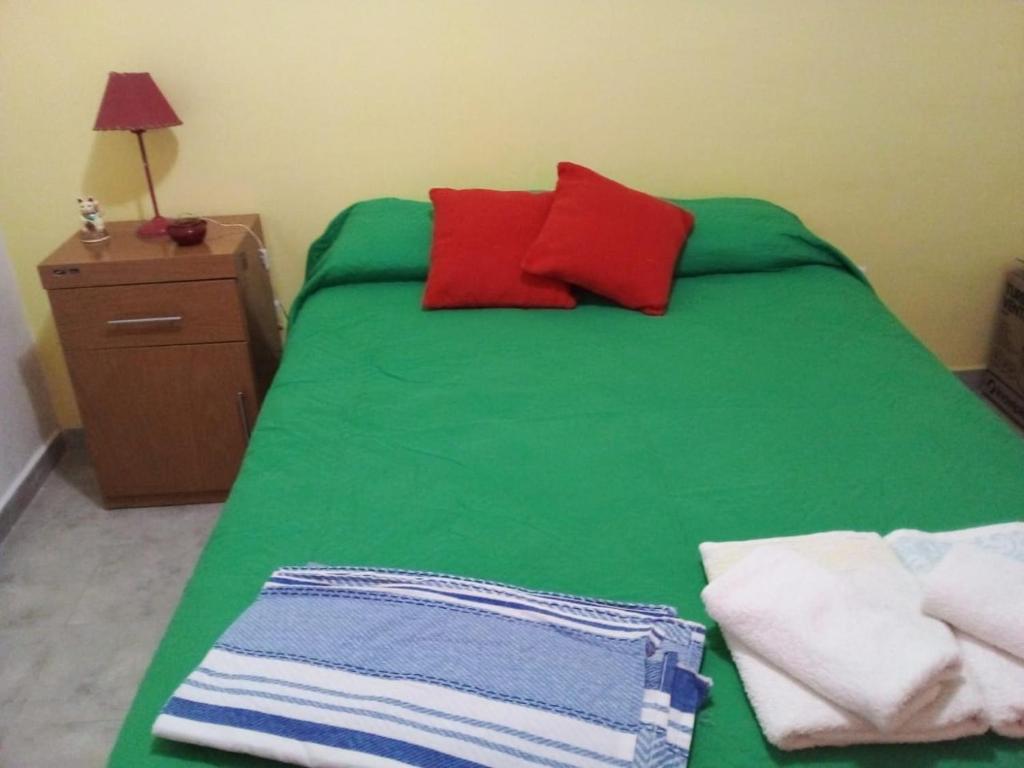 Aldos في سان أنطونيو أويستي: سرير أخضر عليه وسائد ومناشف حمراء