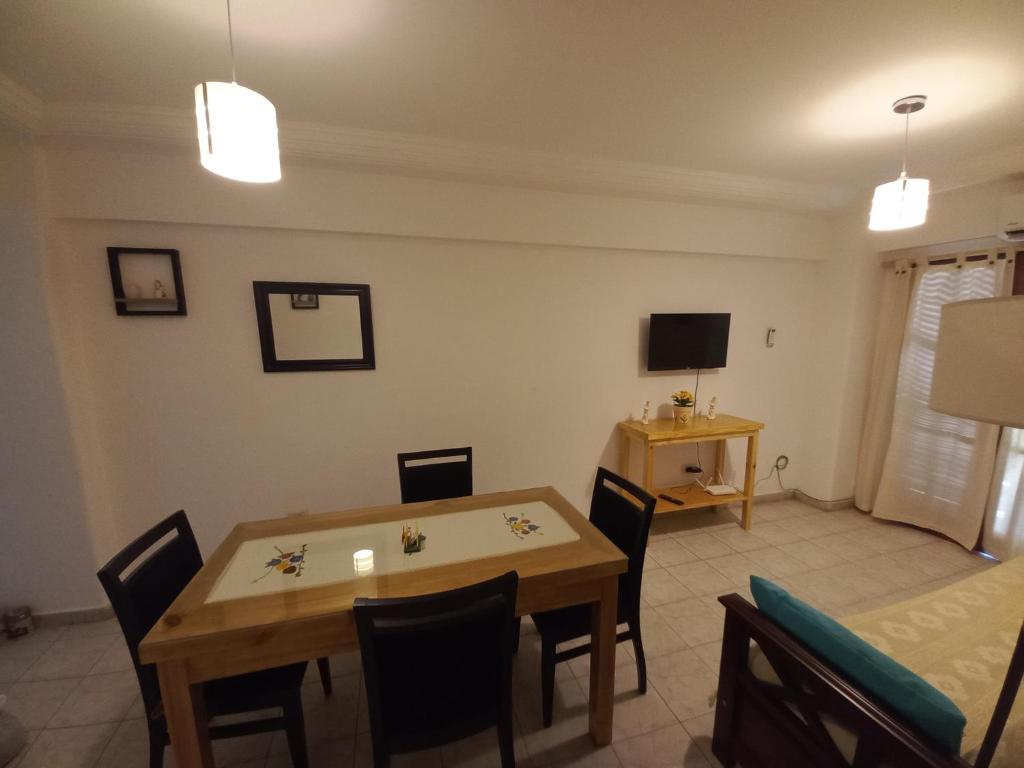 a dining room with a table and chairs and a television at LA SAN JUAN en Zona Norte in San Miguel de Tucumán