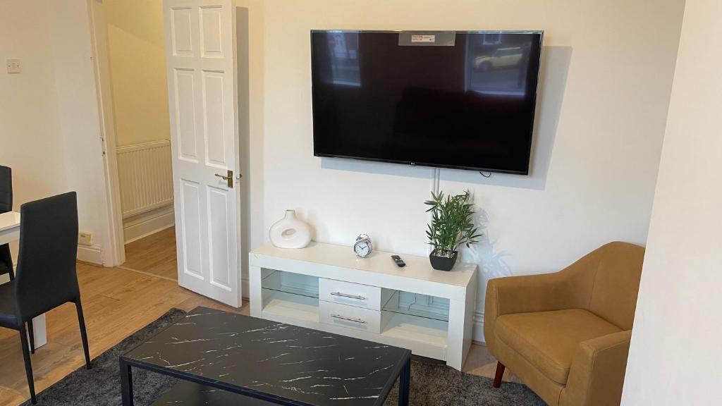 a living room with a flat screen tv on a wall at POTTERS LODGE by Edl Ventures Ltd in Manchester