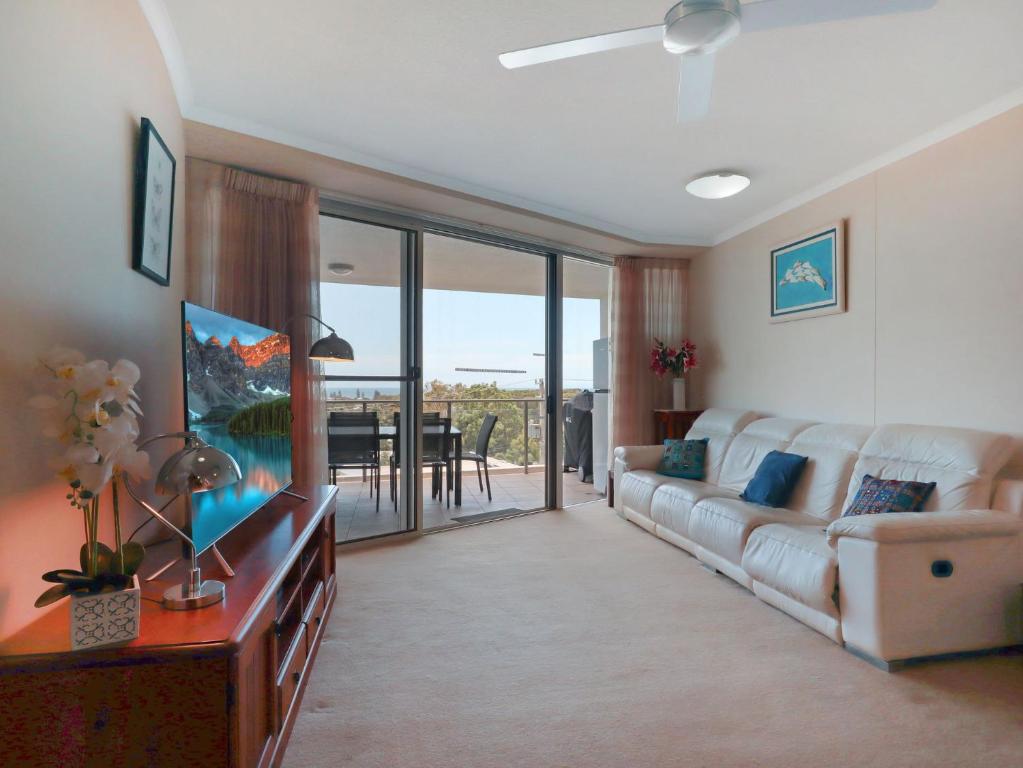 a living room with a white couch and a television at Points North in Caloundra