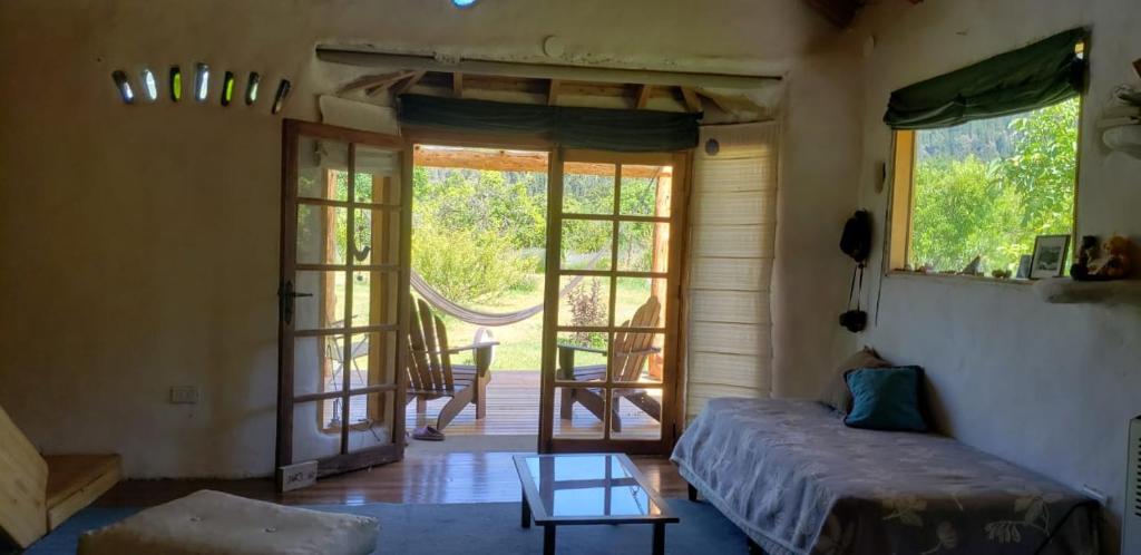 Habitación con cama y puerta con mesa en Casa cerca del lago en Lago Puelo