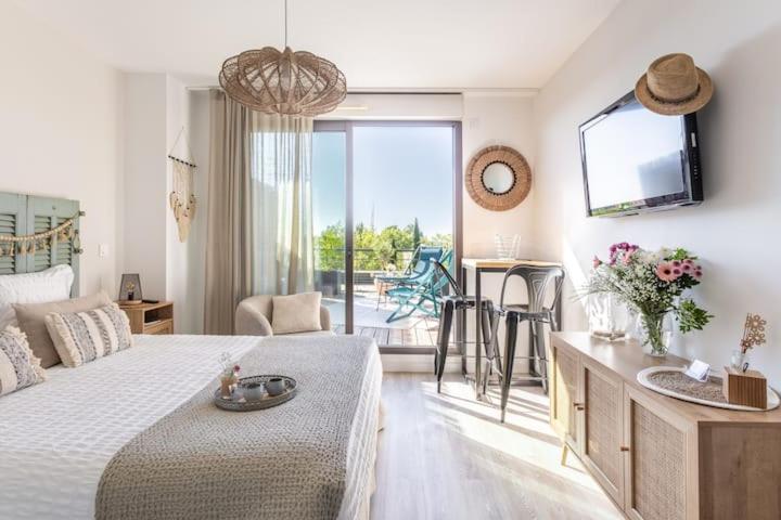 een slaapkamer met een bed en een keuken met een balkon bij Studio Nuitée en Provence 2 in Aix-en-Provence