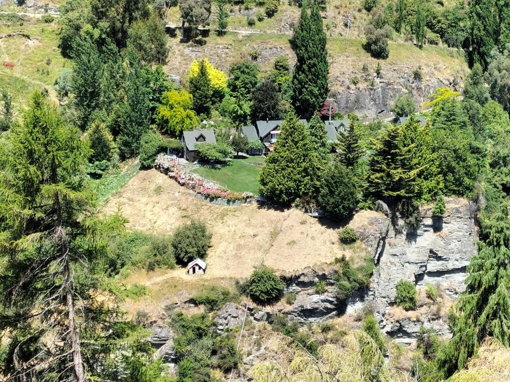 eine Luftansicht eines Hauses mit einem Pferd auf dem Feld in der Unterkunft Trelawn Riverside Cottages in Queenstown