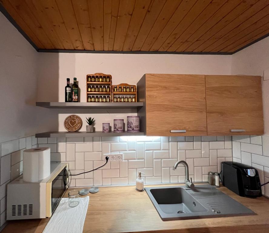 a kitchen with a sink and a counter top at Tenkeshegyi Házikó in Siklós