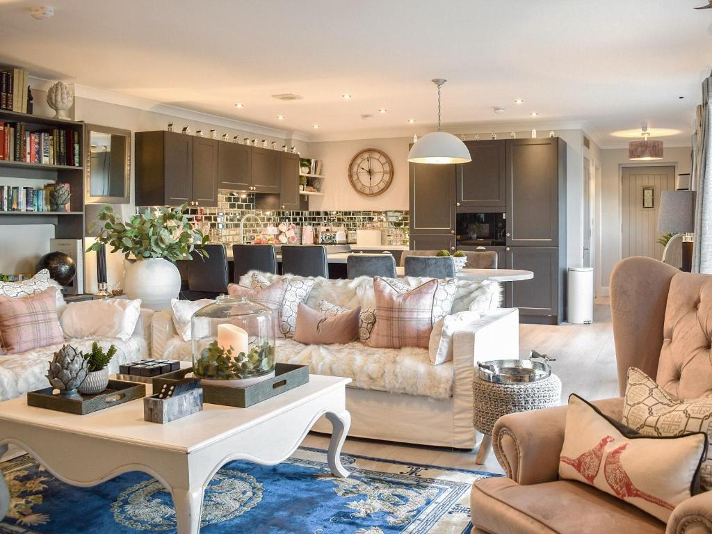 a living room with couches and a table and a kitchen at The Old Stables in Howwood