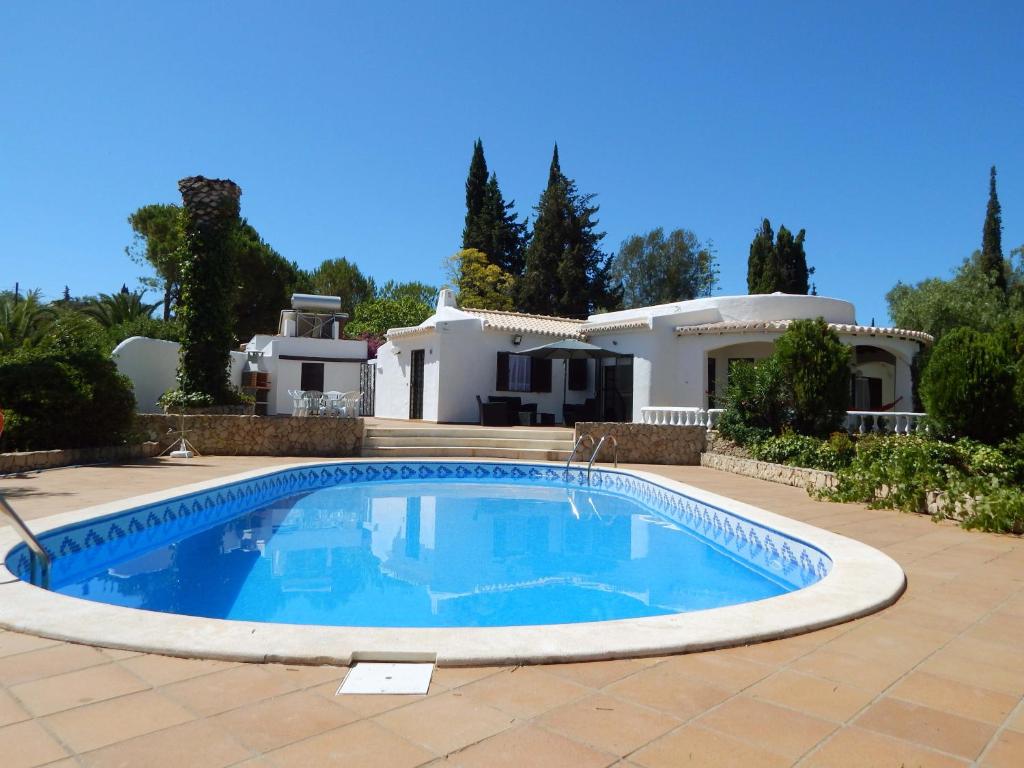 a swimming pool in front of a house at Villa Sol e Mar in Portimão