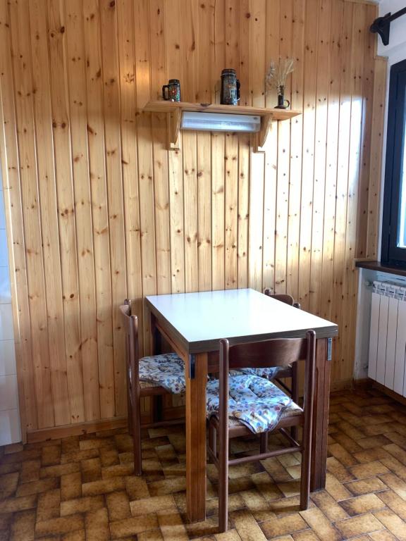 a wooden wall with a table and two chairs at Residence il Cristallo - Appartamento in Ovindoli