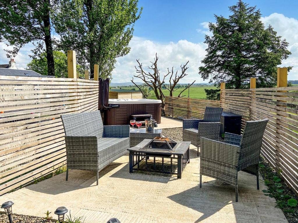 a patio with chairs and a table and a fence at Uk7384 - The Hayloft in Newmilns