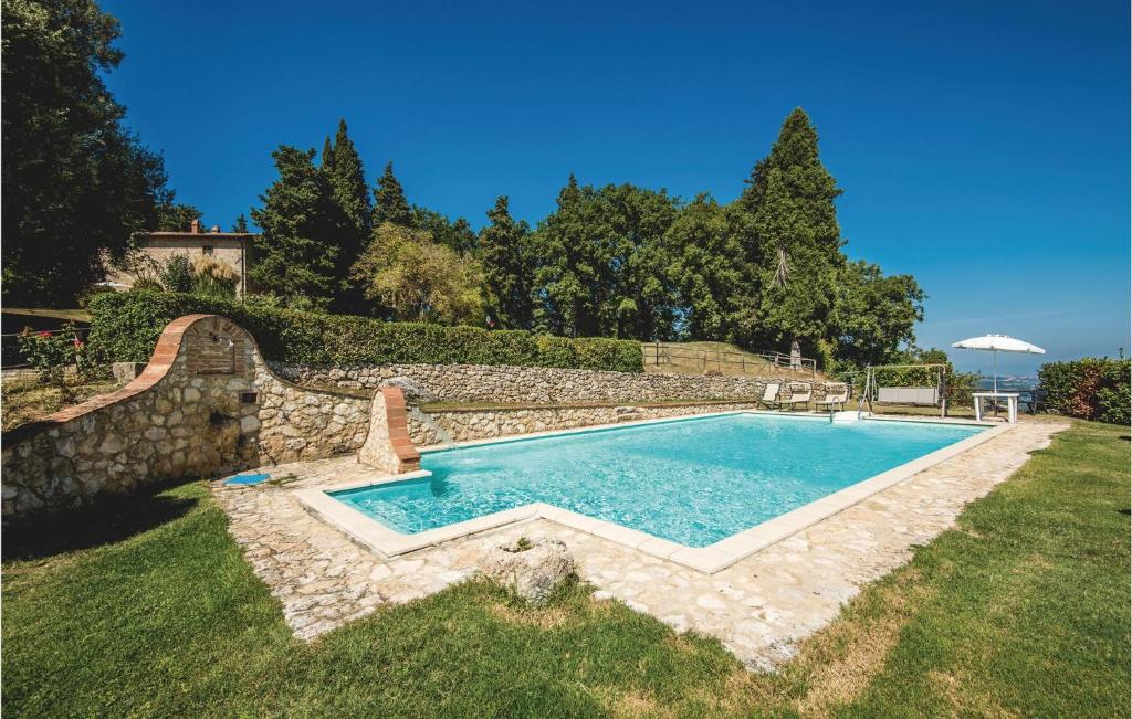 a swimming pool in a yard next to a stone wall at Fonterucola in Camporsevoli