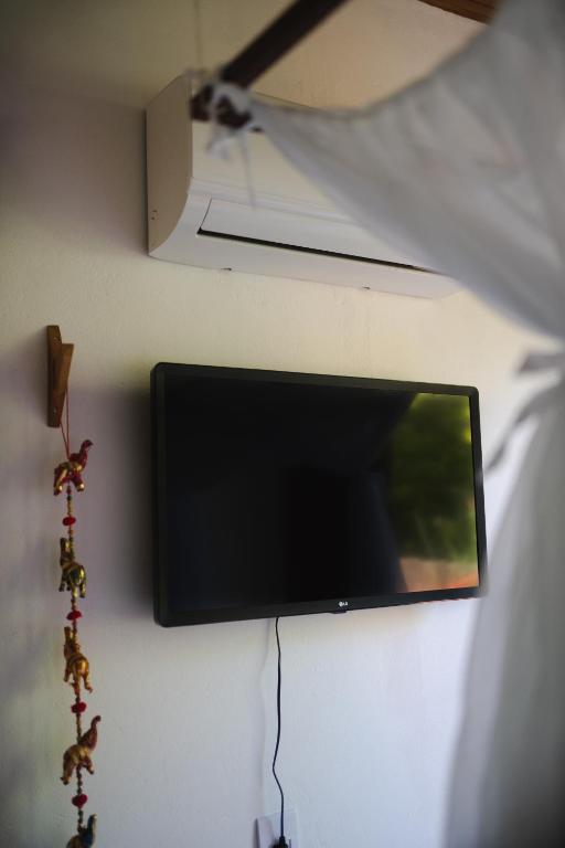 Uma TV ou centro de entretenimento em Casa Canoa - Praia de Algodões