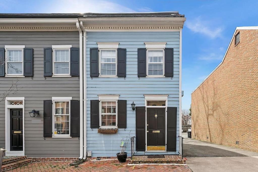 a blue house with black windows and a brick building at Boutique Blue 2 bedroom Old Town House in Alexandria