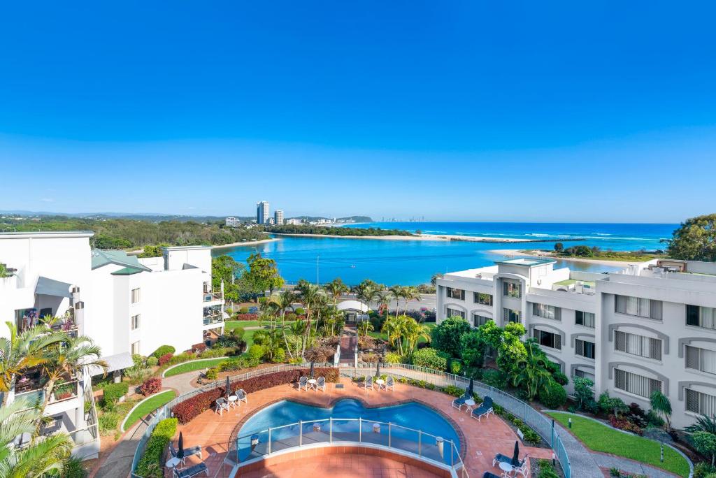 an aerial view of buildings and a body of water at Little Cove Currumbin in Gold Coast