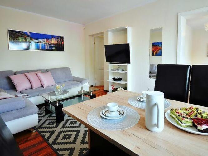 ein Wohnzimmer mit einem Tisch mit Pizza drauf in der Unterkunft Comfortable apartment with a balcony and a sea view, Ustronie Morskie in Ustronie Morskie