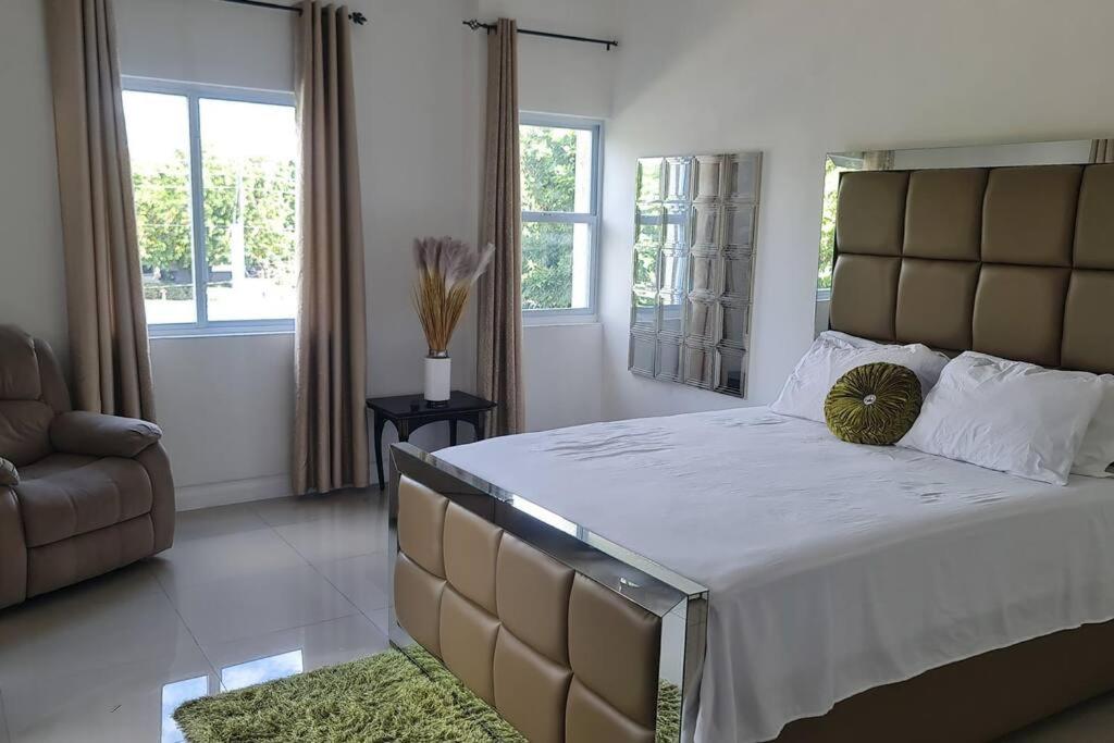 a bedroom with a large bed with a large headboard at Harloes Luxury Suite - Kingston Jamaica in Kingston