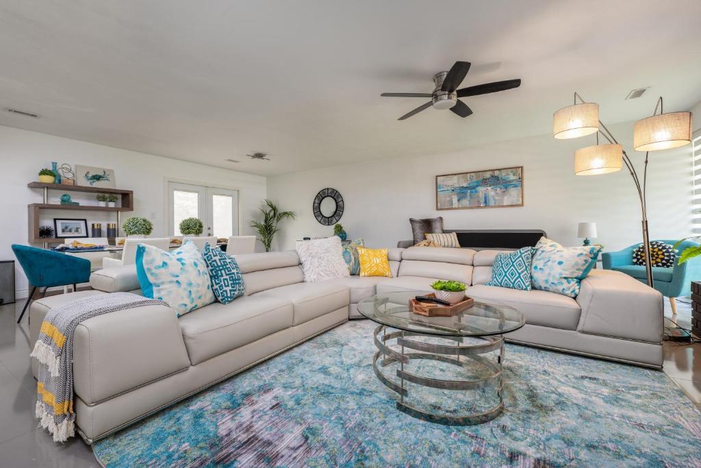 uma sala de estar com um sofá branco e uma mesa de vidro em UF SUNSHINE HOUSE - Patio & BBQ & Fire Pit - Chef Kitchen - Upscale Neighborhood! em Gainesville