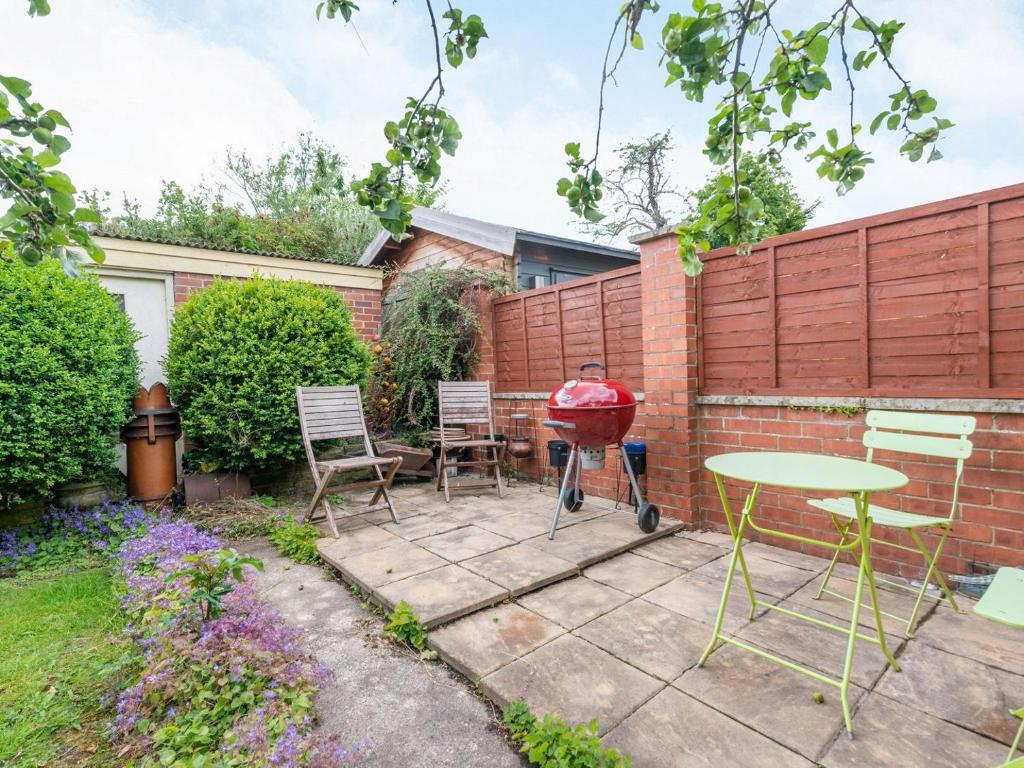 a patio with chairs and a bbq grill at Apple Tree Cottage - Uk37305 in Harrogate