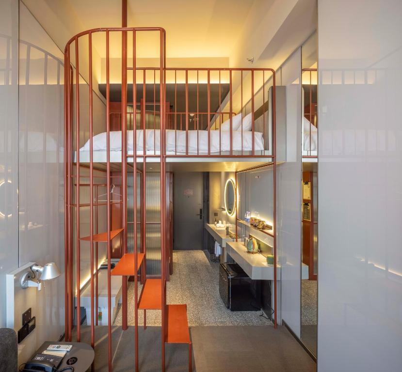 a bathroom with a spiral staircase leading up to a loft at NOA Hotel & Coffee Xiamen in Xiamen