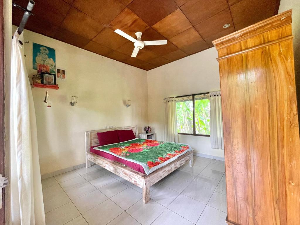 um quarto com uma cama e uma ventoinha de tecto em bucu hidden guest house, and meditation center em Payangan