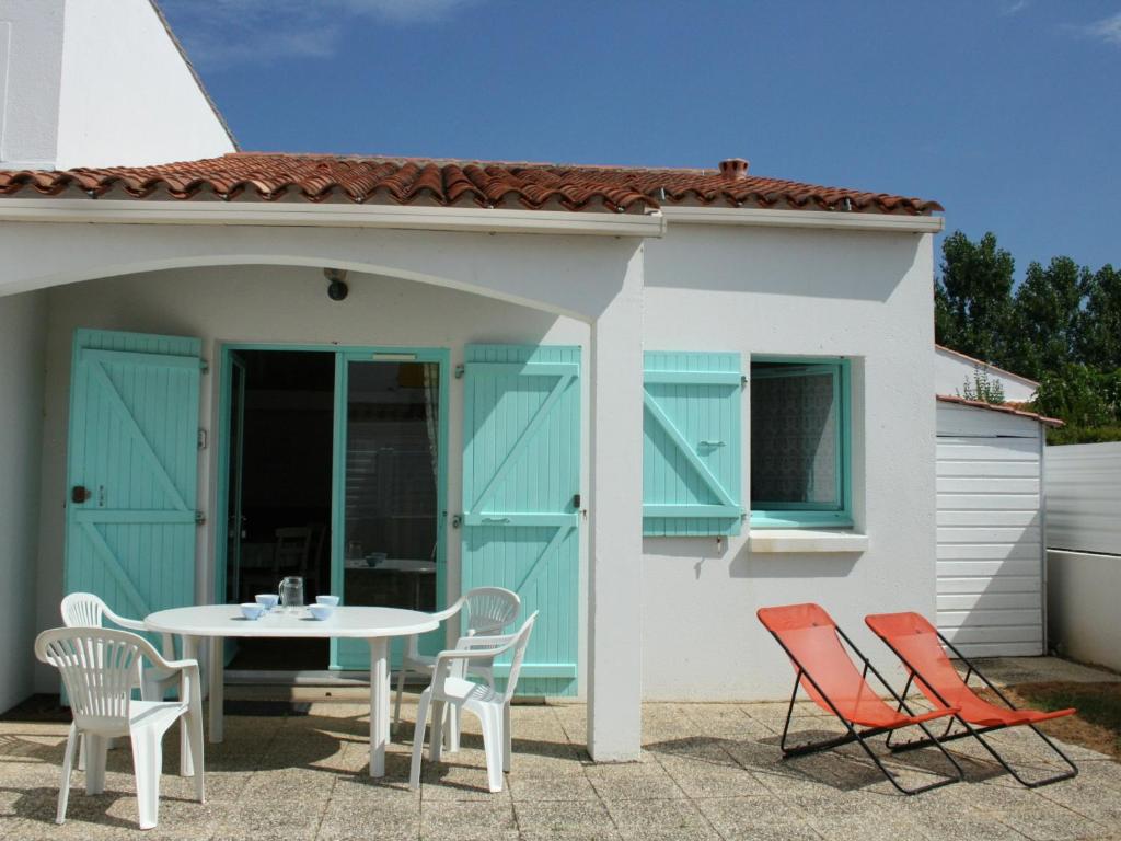 un patio avec une table et des chaises devant une maison dans l'établissement Maison cosy à 900m de la plage avec jardin clos et parking privatif - FR-1-22-182, à La Tranche-sur-Mer