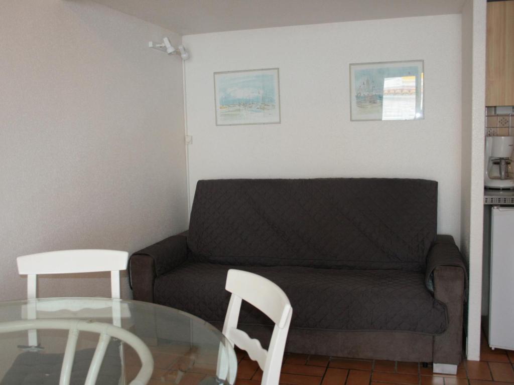 a living room with a couch and a glass table at Maison La Tranche-sur-Mer, 2 pièces, 4 personnes - FR-1-22-182 in La Tranche-sur-Mer