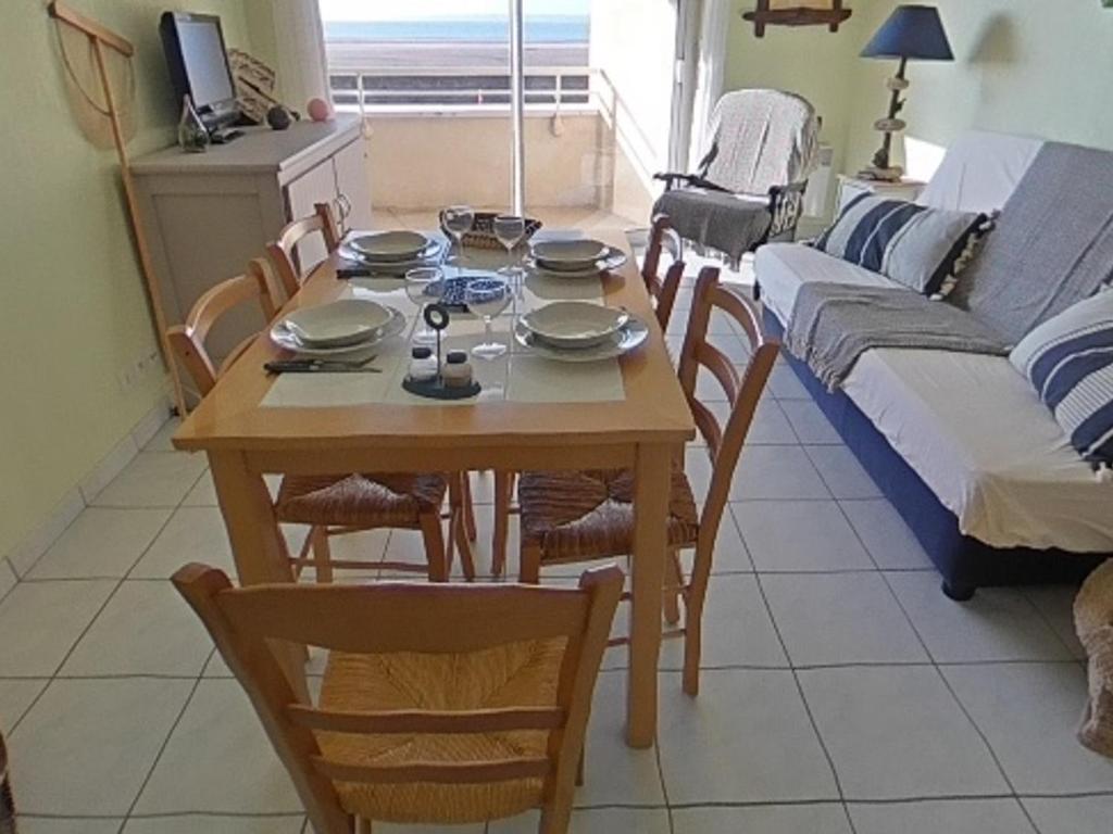 uma sala de estar com uma mesa e cadeiras e um sofá em Appartement Saint-Brevin-les-Pins, 2 pièces, 3 personnes - FR-1-364-141 em Saint-Brévin-les-Pins