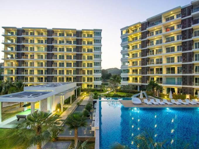 a large hotel with a swimming pool and two large buildings at The Sea Condominium in Sam Roi Yot