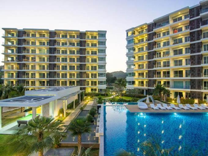 duży hotel z basenem i dwoma dużymi budynkami w obiekcie The Sea Condominium w mieście Sam Roi Yot