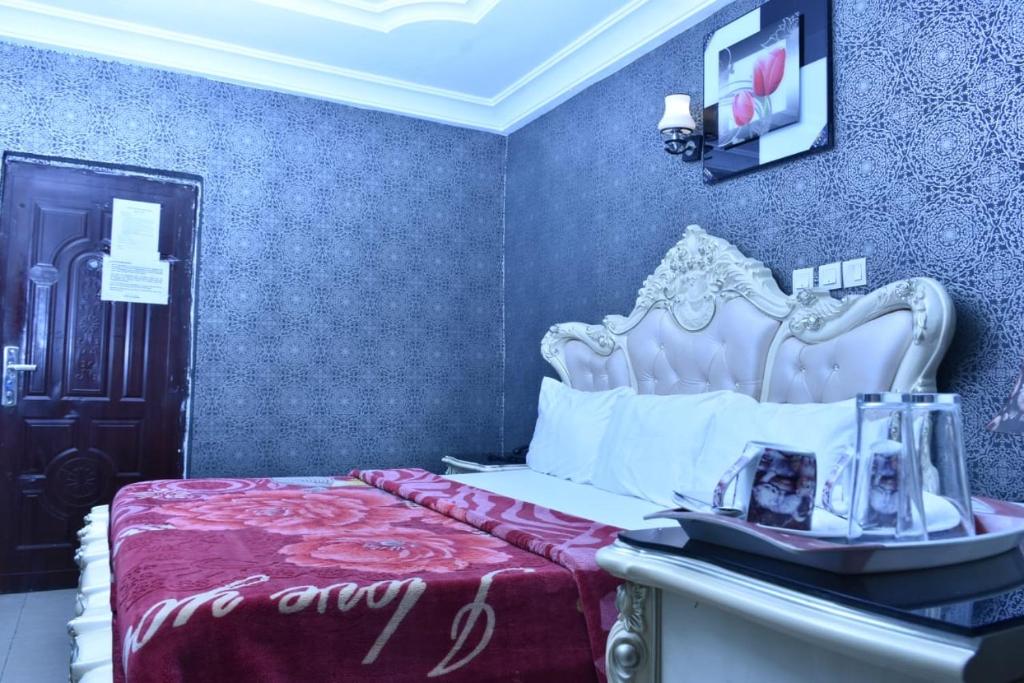 a bedroom with a bed with an ornate head board at World Class Hotel & Apartments in Abuja