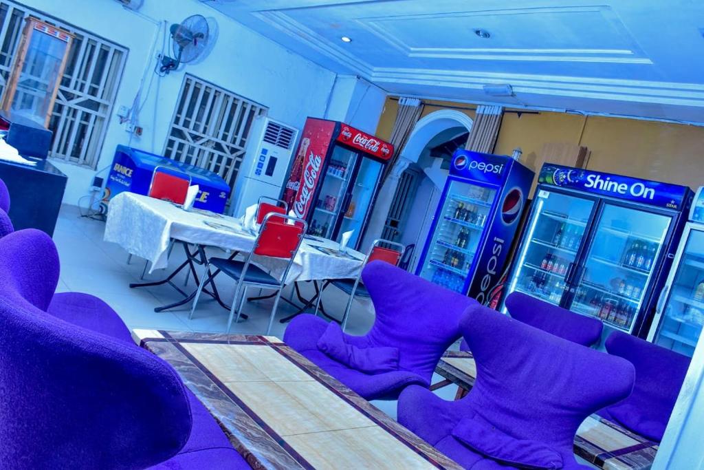 a room with purple chairs and a table and gas pumps at World Class Hotel & Apartments in Abuja