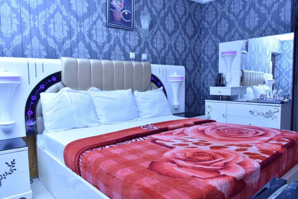 a bedroom with a large bed with a rose blanket at World Class Hotel & Apartments in Abuja