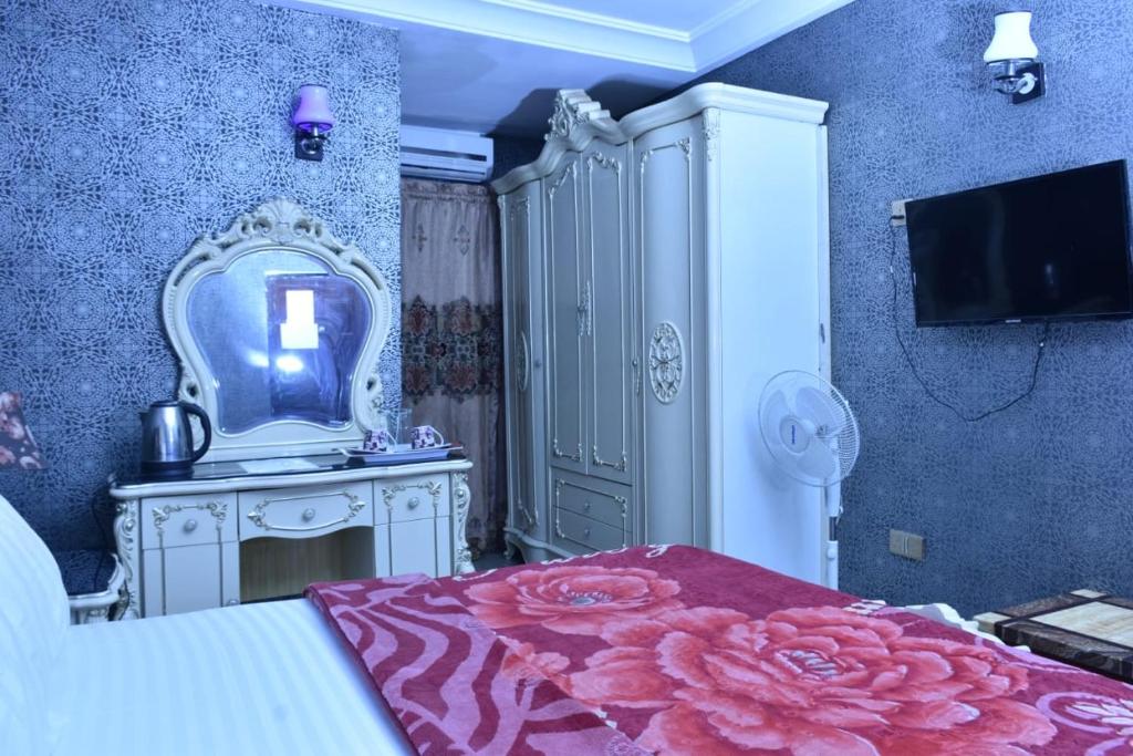 a bedroom with a bed with a dresser and a mirror at World Class Hotel & Apartments in Abuja