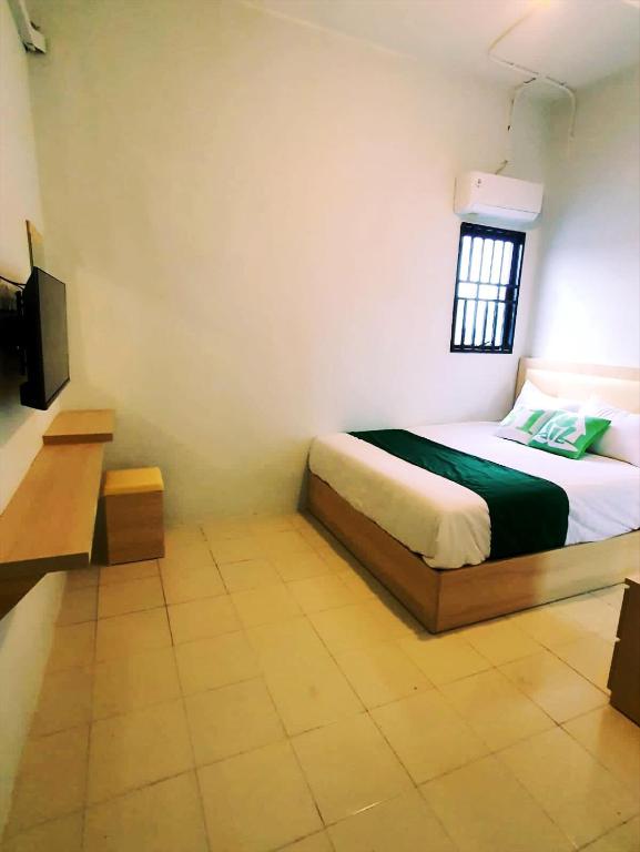 a small bedroom with a bed and a television at Homestay 81 Batu Batam in Nagoya