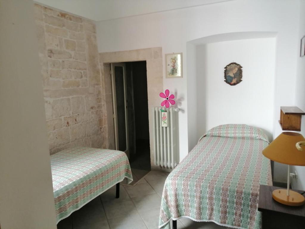 a bedroom with two beds and a flower on the wall at Il Giardino della Nonna in Alberobello