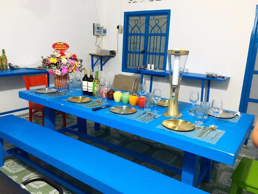 uma mesa azul com pratos e copos em SANTORINI HOME RESORT em Vạn Ninh