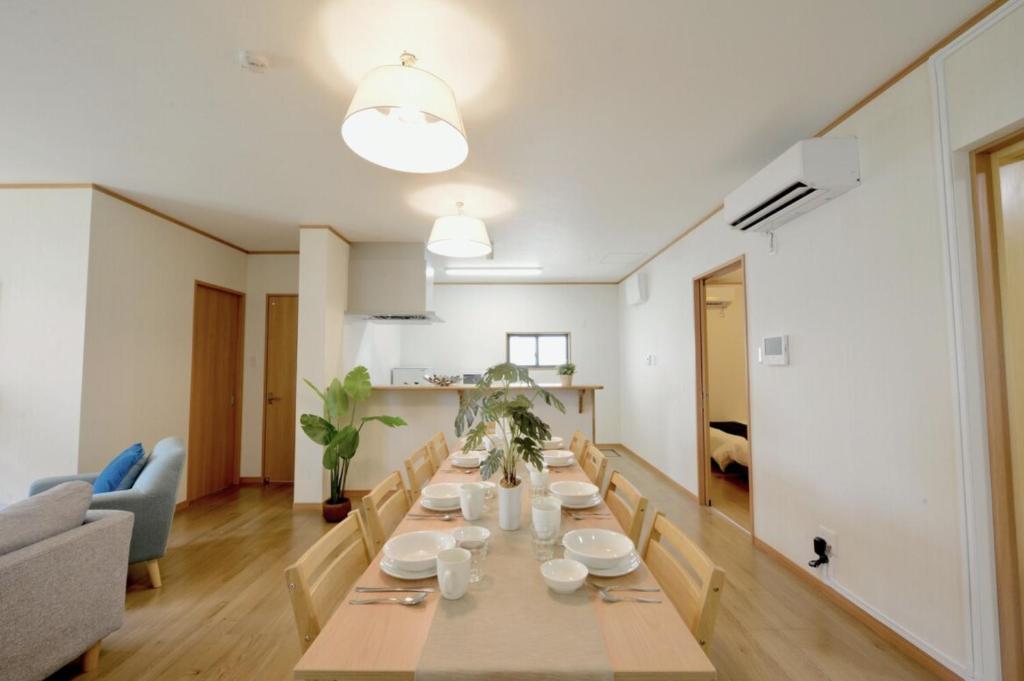 uma sala de jantar com uma mesa longa numa sala de estar em Orange Line em Inbu