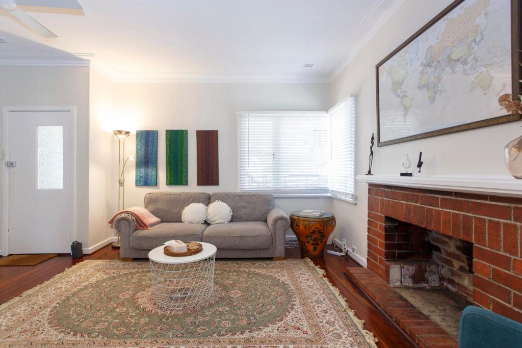 ein Wohnzimmer mit Couch und Kamin in der Unterkunft Home Away - 2 Bedroom Cottage in Bicton