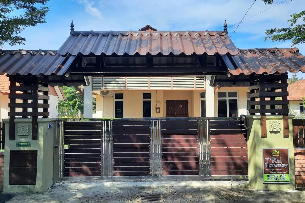 a house with a gate in front of it at T'Rai Homestay in Dungun