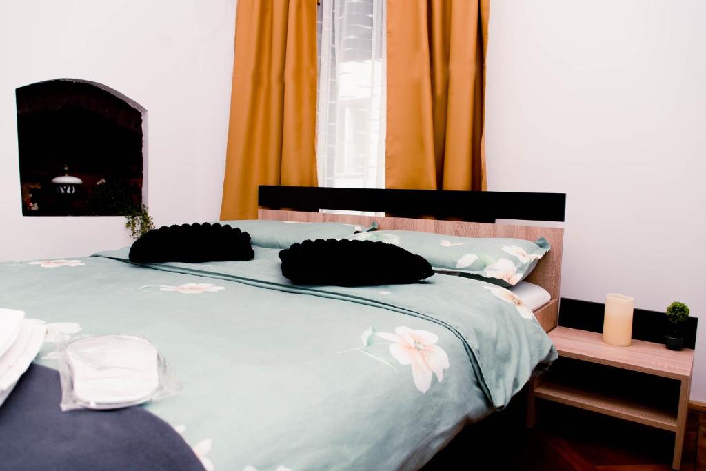 a blue bed with black pillows with flowers on it at Studio Leena in Sibiu