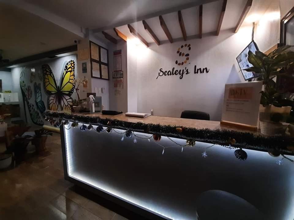 a bar in a restaurant with butterflies on the wall at Sealey's Inn in Sipalay