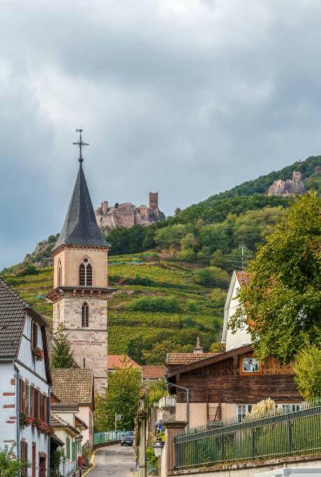 a small town with a church and a castle on a hill at Studio Marie-Rose in Ribeauvillé
