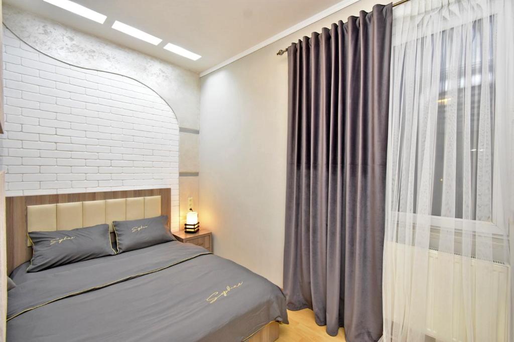 a bedroom with a bed and a large window at Apart House in Yrevan Mashtots Avenue in Yerevan