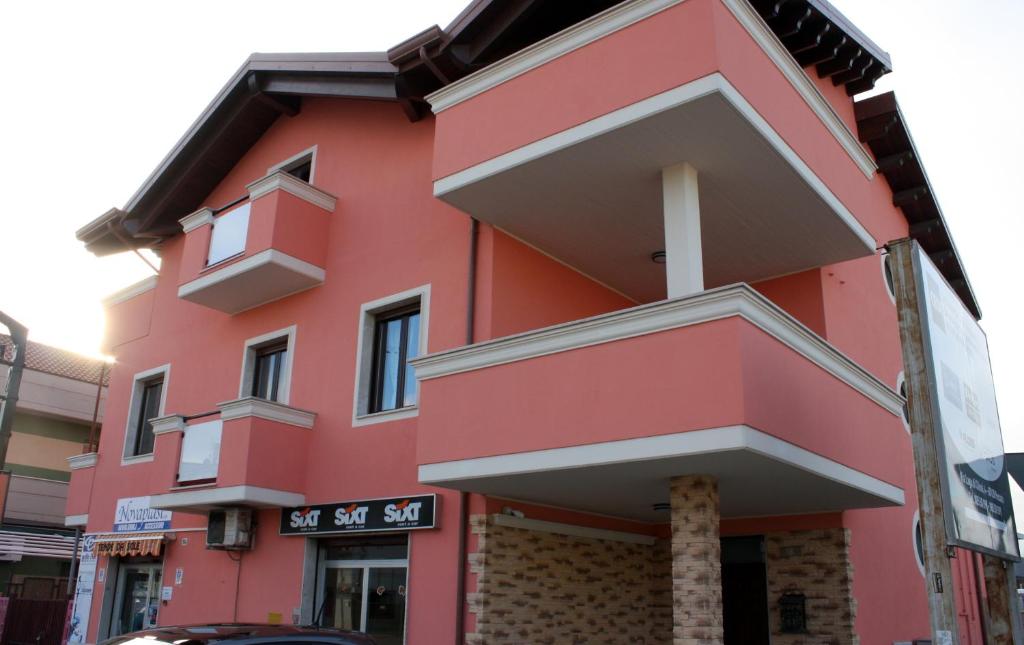 ein rotes Gebäude mit Balkonen auf einer Straße in der Unterkunft Bed & Breakfast La Perla Rosa in Pescara